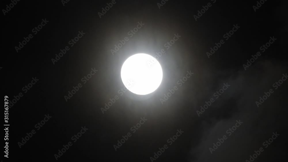 Clouds passing by moon at night. Full moon at night with clouds in real time. Clouds passing by moon at night. Full moon at night with clouds in real time.