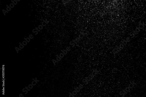 white powder on black background, in defocus. Background abstract.