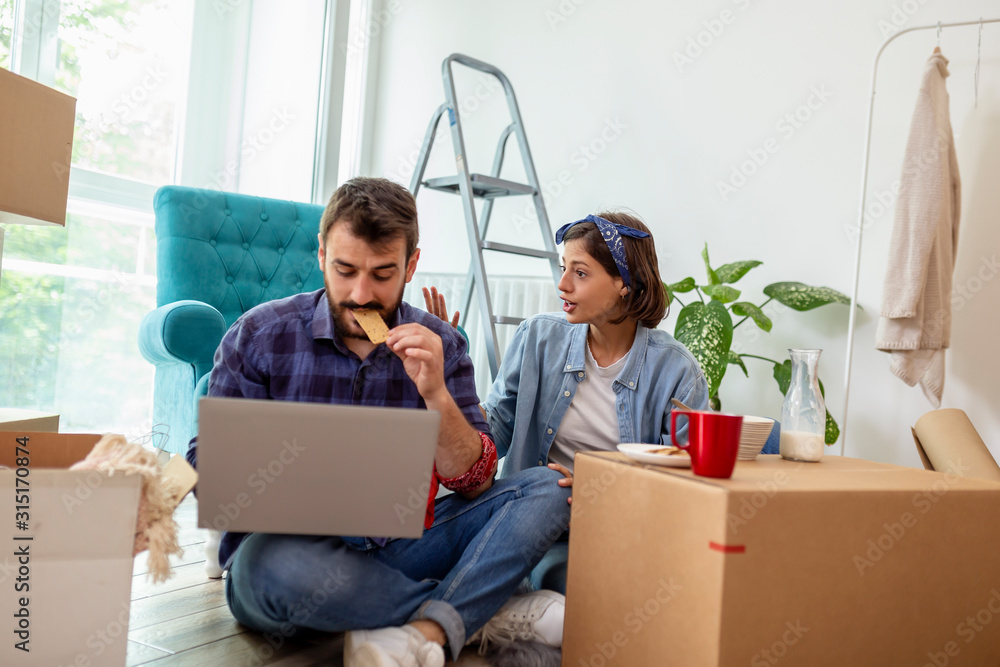 Couple having breakfast and searching for apartment redecoration ideas Couple having breakfast and searching for apartment redecoration ideas