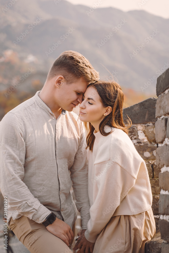 beautiful young couple hugging at the Great Wall of China. Newly married couple on their honemoon to Great Wall near Beijing China. Stylish couple exploring one of the wonders of the world. beautiful young couple hugging at the Great Wall of China. Newly married couple on their honemoon to Great Wall near Beijing China. Stylish couple exploring one of the wonders of the world.