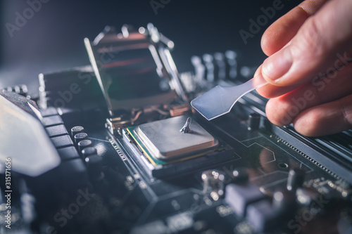 Fototapeta Application of thermal paste on the laptop processor chip for high-quality cooling