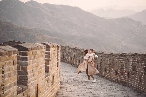 young couple running and twirling at the Great Wall of China. Newly married couple on their honeymoon to the Great Wall of China near Beijing China.