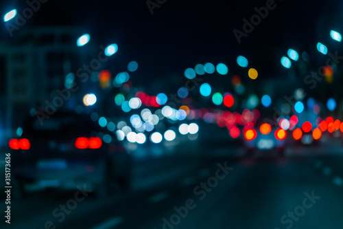 Defocused picture of night street car traffic - view from road. Colorful night life background. photo