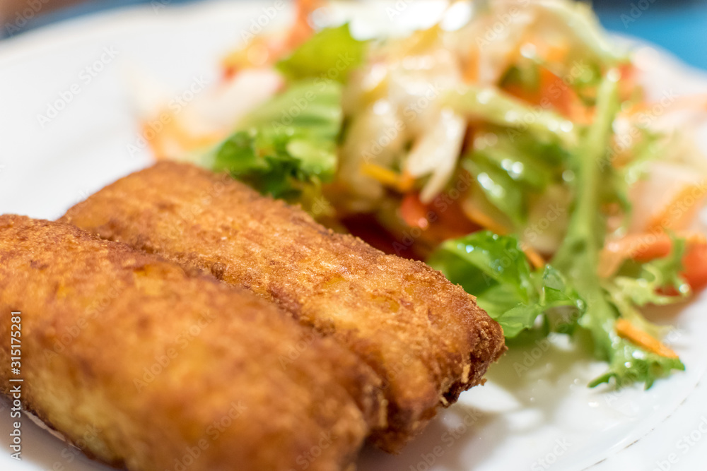 Potato croquette filled with cheese and herbs served with fresh green salad, tomatoes and pepper