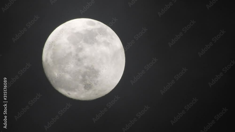Full moon on dark cloudy night. Clouds passing by the moon, real time shot. Full moon on dark cloudy night. Clouds passing by the moon, real time shot.