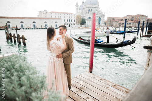 Wedding couple on the nature is hugging each other. Beautiful model girl in white dress. Man in suit.Venice, Italy