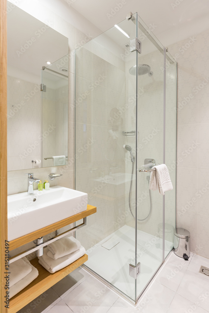 Interior of a luxury hotel bathroom with glass shower cabin - obrazy, fototapety, plakaty 