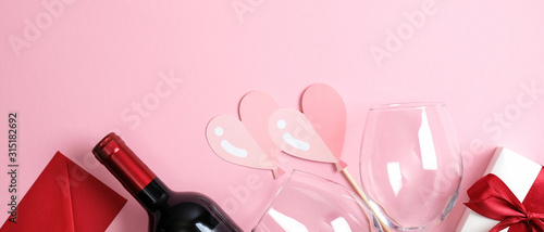 Valentine s Day banner template. Top view pink background with valentine gift  bottle of wine champagne  glass  hearts. Minimal flat lay style composition. Romantic dinner couple concept