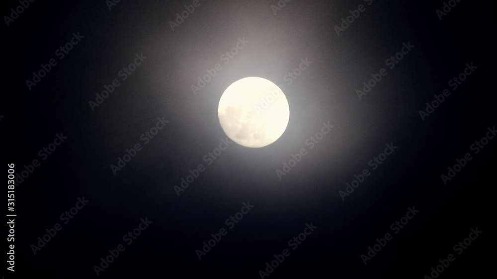Full moon on dark cloudy night. Clouds passing by the moon, real time shot. Full moon on dark cloudy night. Clouds passing by the moon, real time shot.