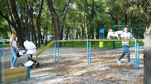 Wallpaper Mural Active family with baby stroller and pet Jack Russell Terrier on dog playground Torontodigital.ca