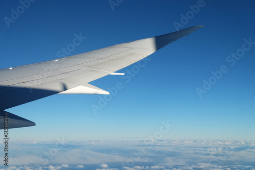 View from airplane window with sky and white clouds at noon © lightscience