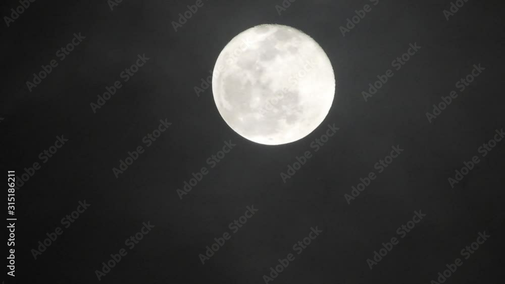 Full moon on dark cloudy night. Clouds passing by the moon, real time shot. Full moon on dark cloudy night. Clouds passing by the moon, real time shot.