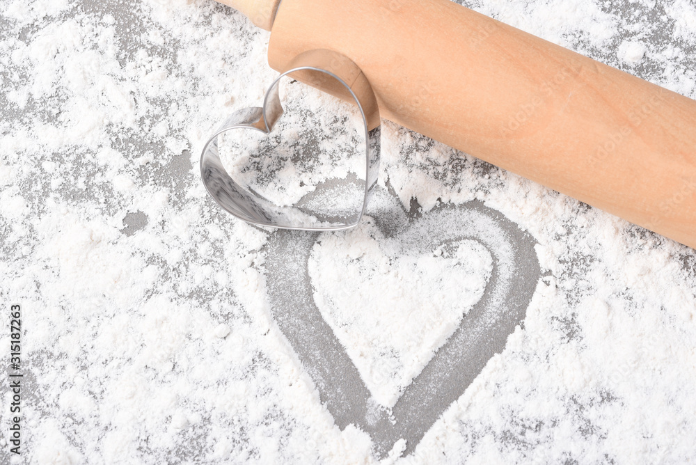 Flour, cookie cutters shaped as heart and rolling pin on a stone Stock  Photo by ©karidesign 107741166