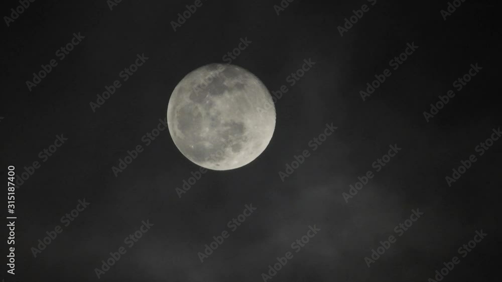 Clouds passing by moon at night. Full moon at night with clouds in real time. Clouds passing by moon at night. Full moon at night with clouds in real time.