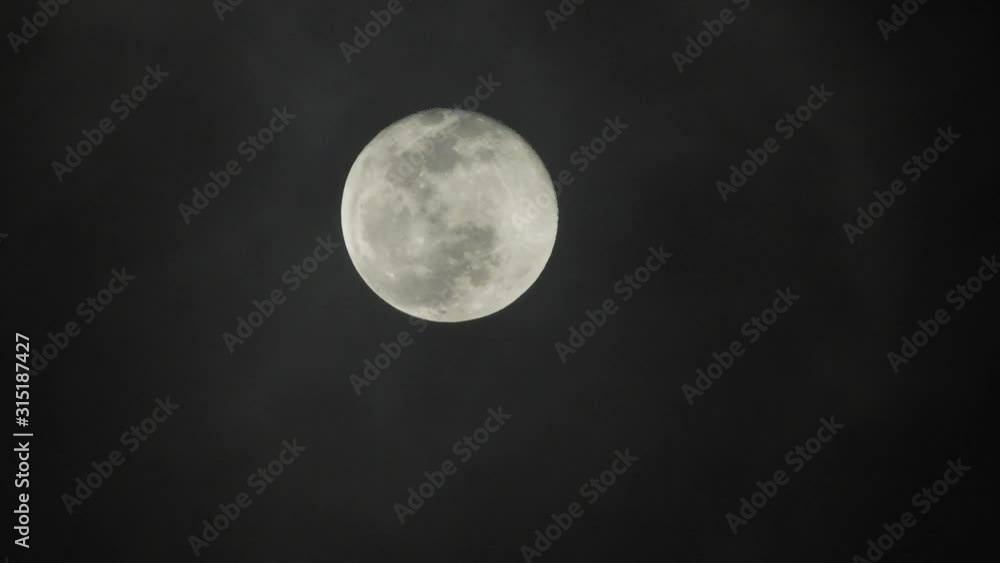 Full moon on dark cloudy night. Clouds passing by the moon, real time shot. Full moon on dark cloudy night. Clouds passing by the moon, real time shot.