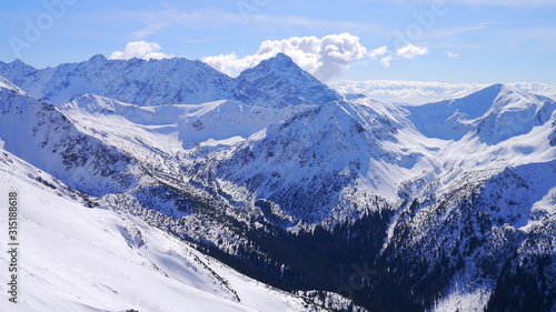 Panorama ze szczytu górskiego na zaśnieżone górskie szczyty © Marcin