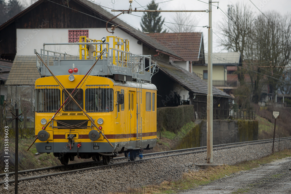 Railway construction machinery - a yellow catenary maintenance  draisine is standing on an open track.