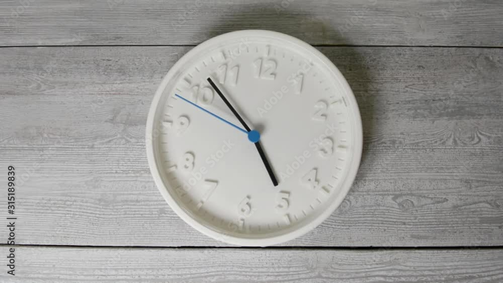 White clock on wooden surface. Moving second hand White clock on wooden surface. Moving second hand