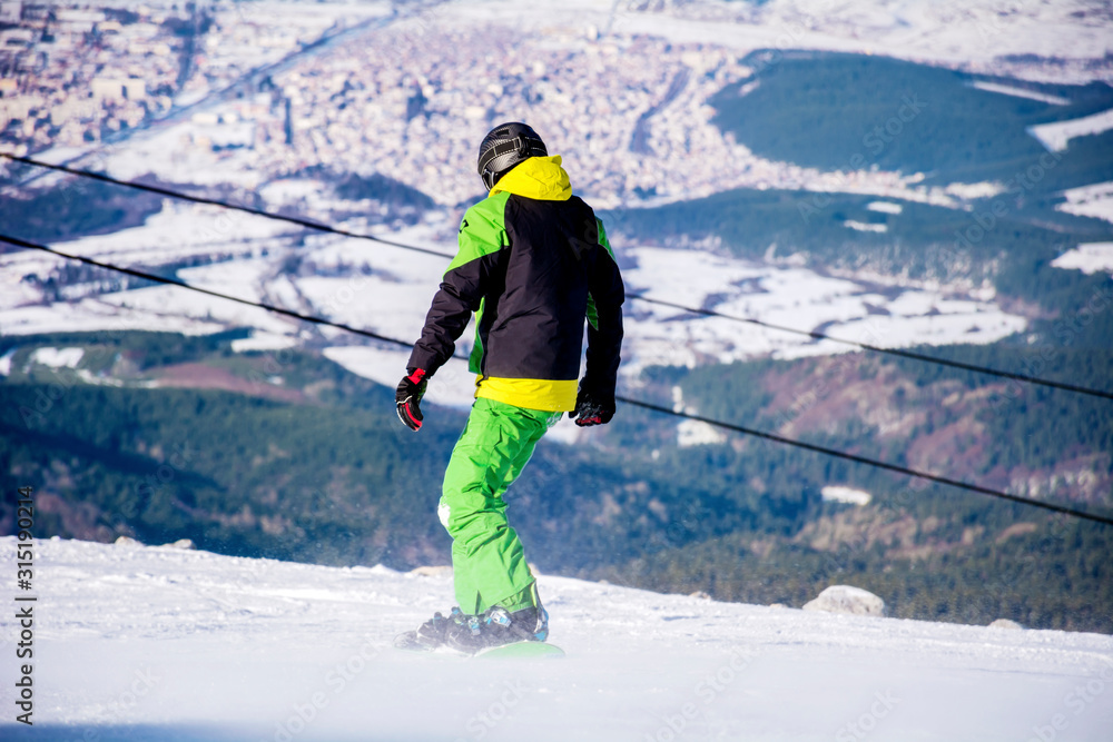 A Young Man Snowboarder in the Winter Mountain A Young Man Snowboarder in the Winter Mountain