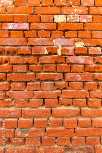 wall of old peeling red bricks