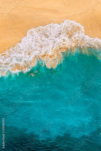 Beautiful sandy beach with turquoise sea, vertical view. Drone view of tropical turquoise ocean beach Nusa penida Bali Indonesia. Lonely sandy beach with beautiful waves. Beaches of Indonesia. © MISHA