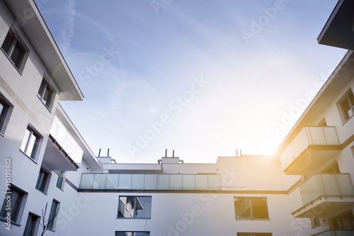 Modern apartment buildings on a sunny day with a blue sky. Facade of a modern apartment building.Glass surface with sunlight. © Grand Warszawski