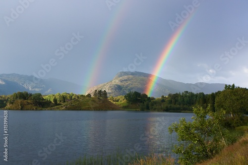 A double rainbow above norwegiean mountain and lake