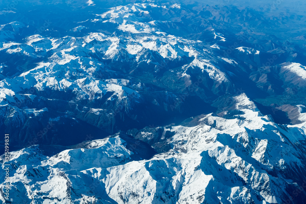 Aerial view of the Pyrenees mountains from the airplane window in winter time