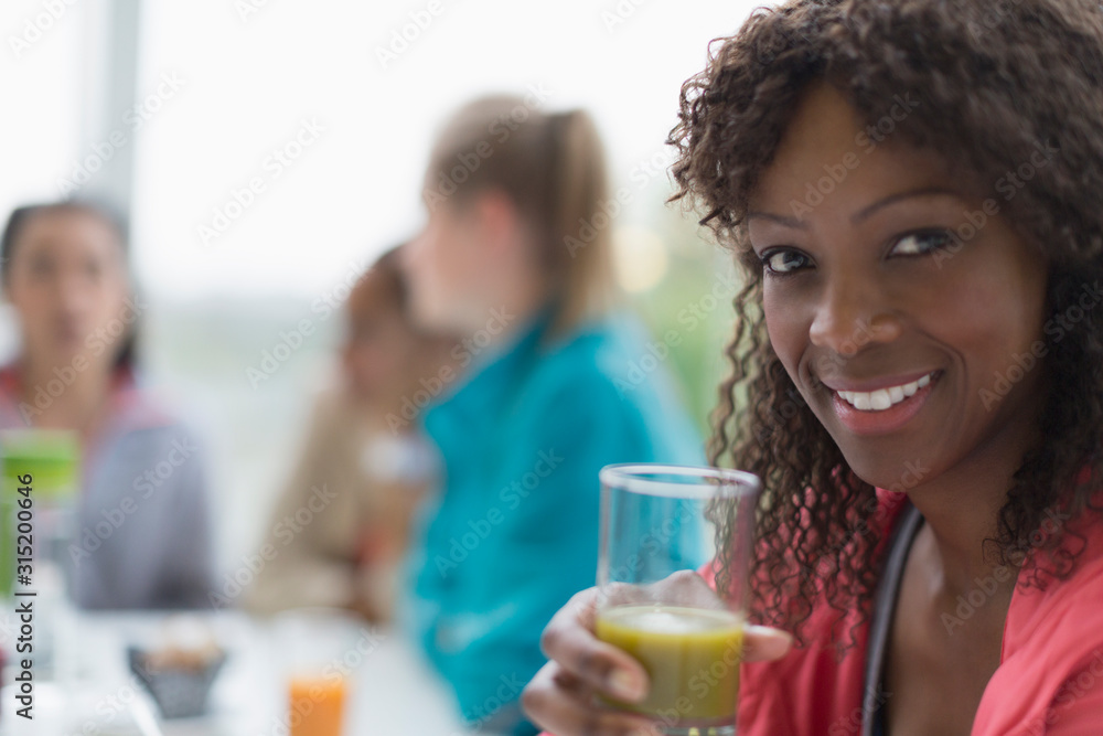Portrait smiling woman drinking healthy green smoothie at cafe friends Portrait smiling woman drinking healthy green smoothie at cafe friends