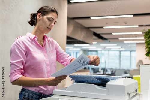 Businesswoman using photocopier in office