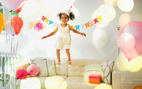 Playful girl jumping on sofa photo