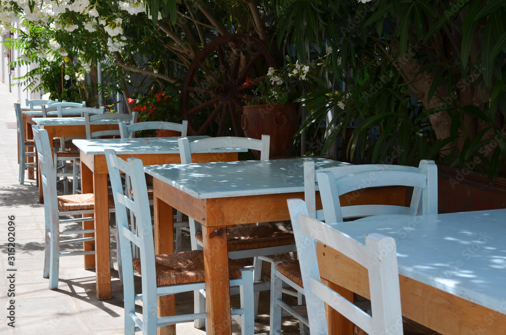 Wooden table and blue chairs on terrace in restaurant. Patio restaurant with empty sitting place.