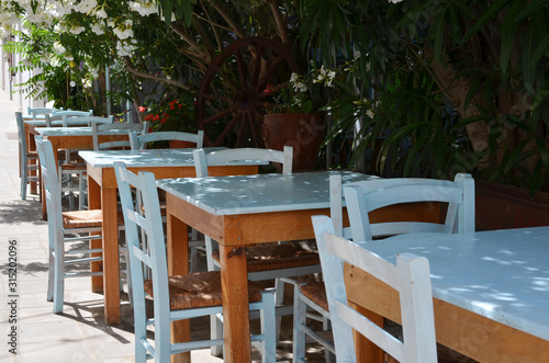 Wooden table and blue chairs on terrace in restaurant. Patio restaurant with empty sitting place. © photosbysabkapl