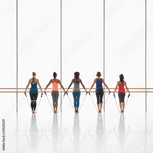 Women exercising with resistance bands in exercise class gym studio photo