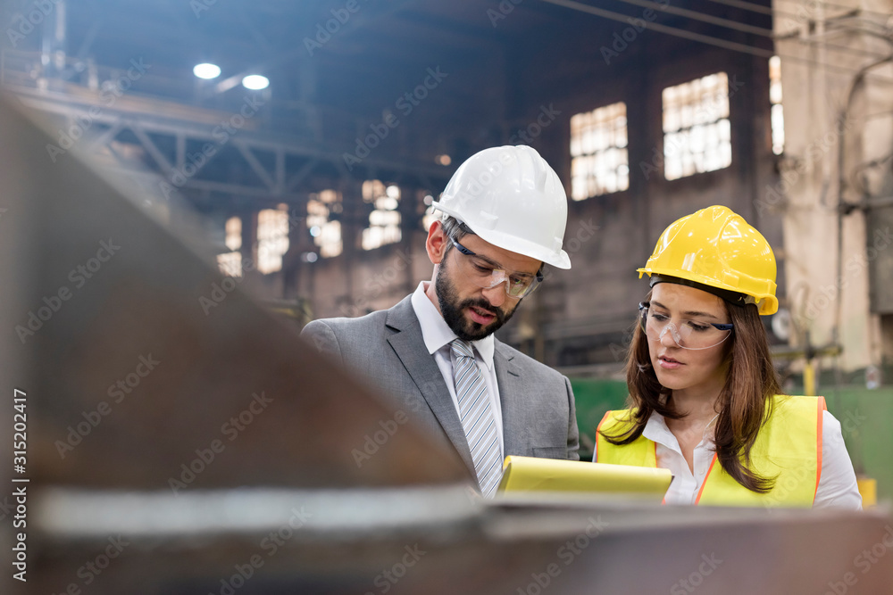 Manager and female steel worker meeting in factory Manager and female steel worker meeting in factory