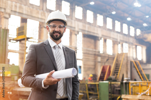 Portrait smiling manager with blueprints in steel factory photo