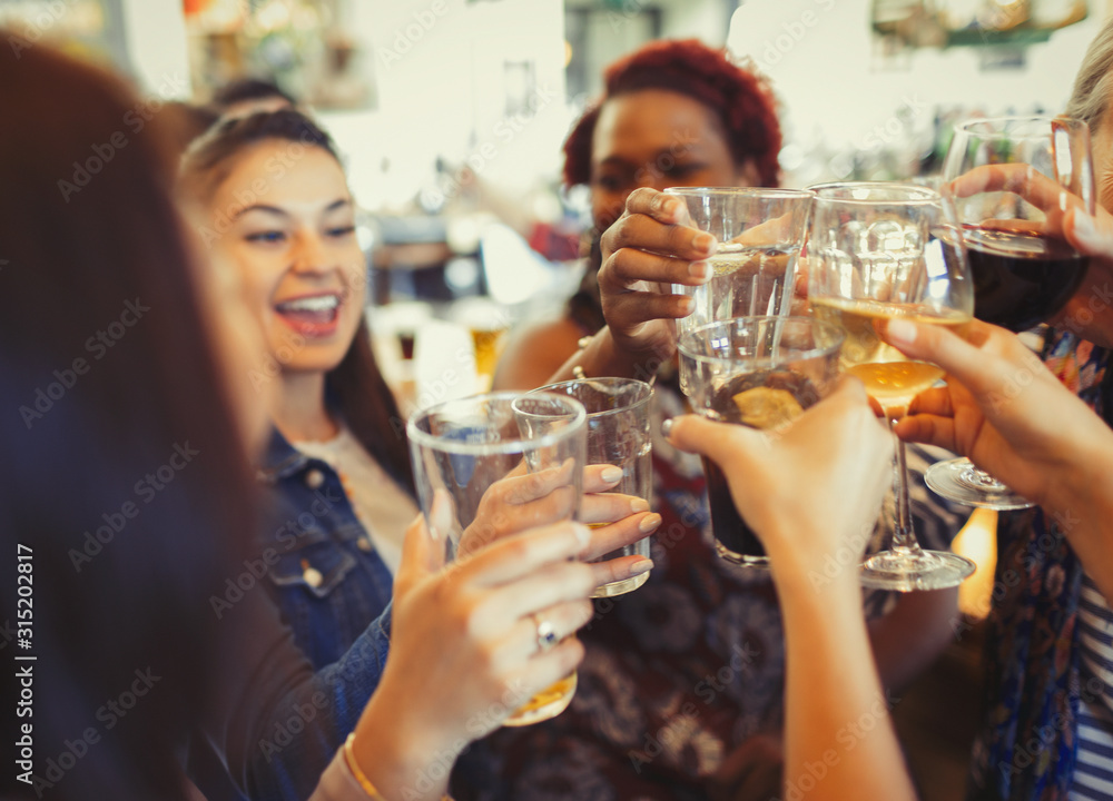 Enthusiastic women celebrating, toasting beer and wine glasses at bar Enthusiastic women celebrating, toasting beer and wine glasses at bar