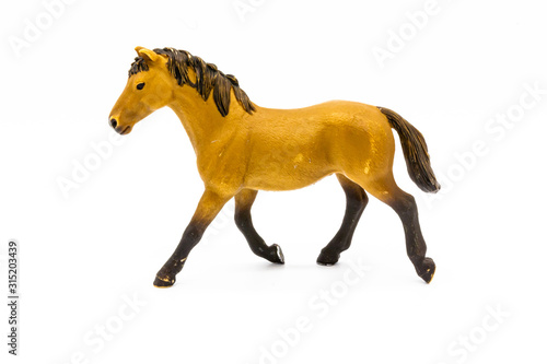 Toy brown foal isolated on white. Cute little toy horse isolated on white. Farm animals collection Toy brown foal isolated on white.