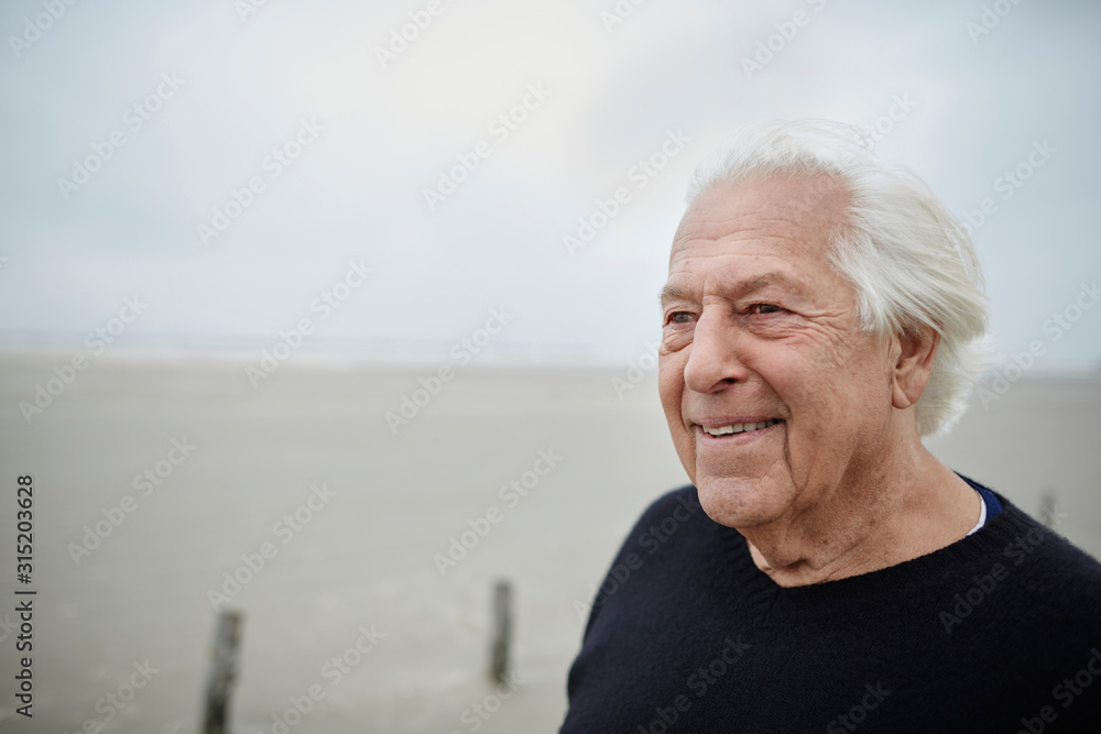 Smiling senior man looking away on beach Smiling senior man looking away on beach
