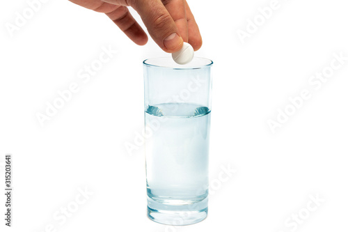 An effervescent aspirin tablet is thrown into a glass of water.