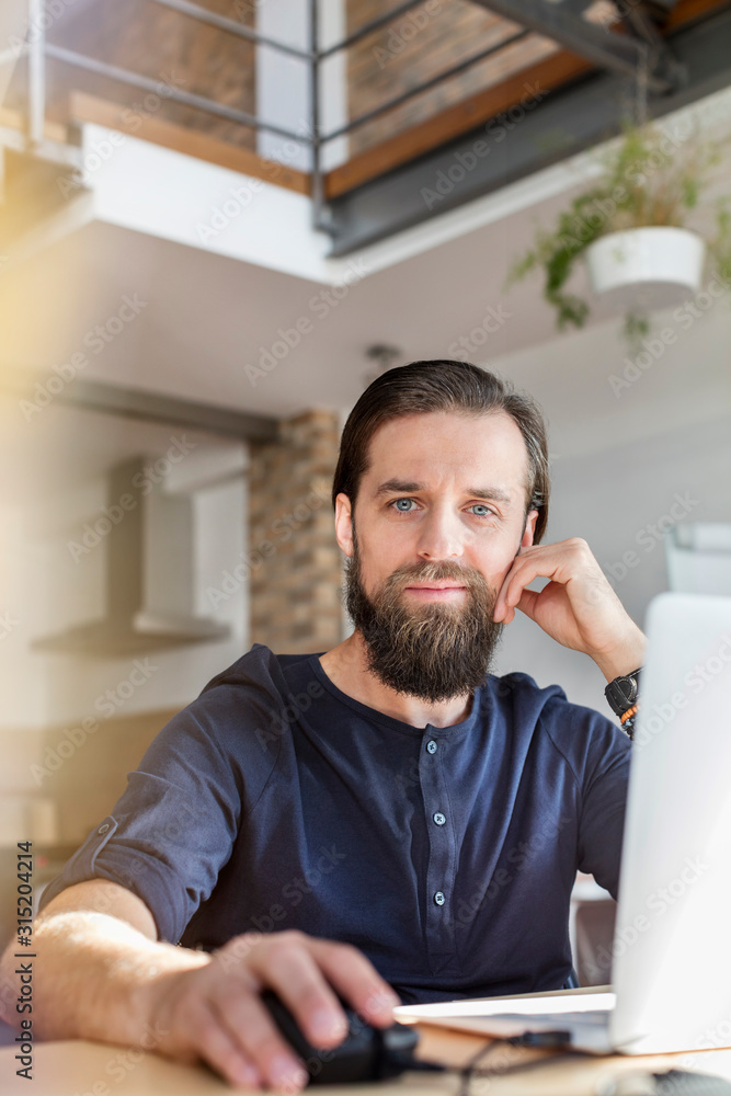 Portrait confident male design professional working at laptop in office Portrait confident male design professional working at laptop in office