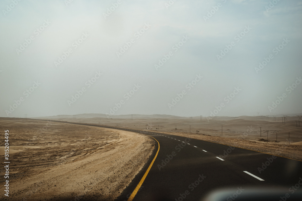 High winds causing limited visibility and blowing sand across the road