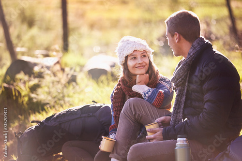 Young couple with backpacks camping, drinking coffee photo