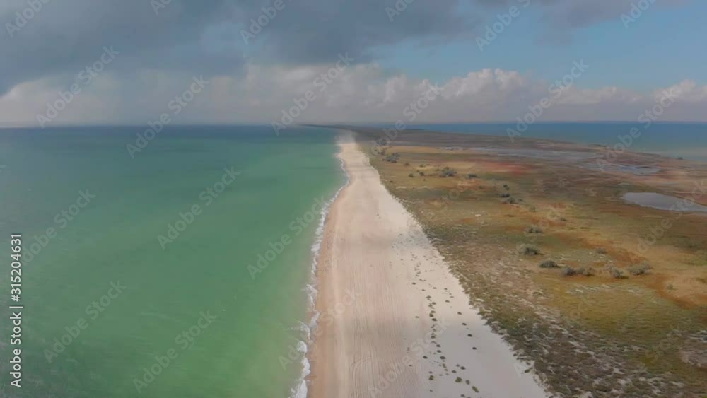 Flying along the seashore, white waves on deserted beach Flying along the seashore, white waves on deserted beach