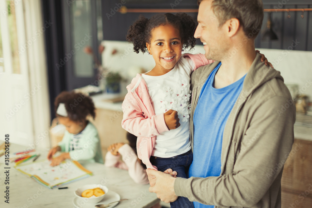 Portrait smiling multi-ethnic father and daughter in kitchen Portrait smiling multi-ethnic father and daughter in kitchen