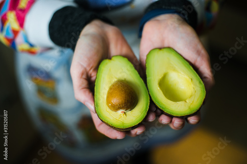 Woman hands holding an avocado.
