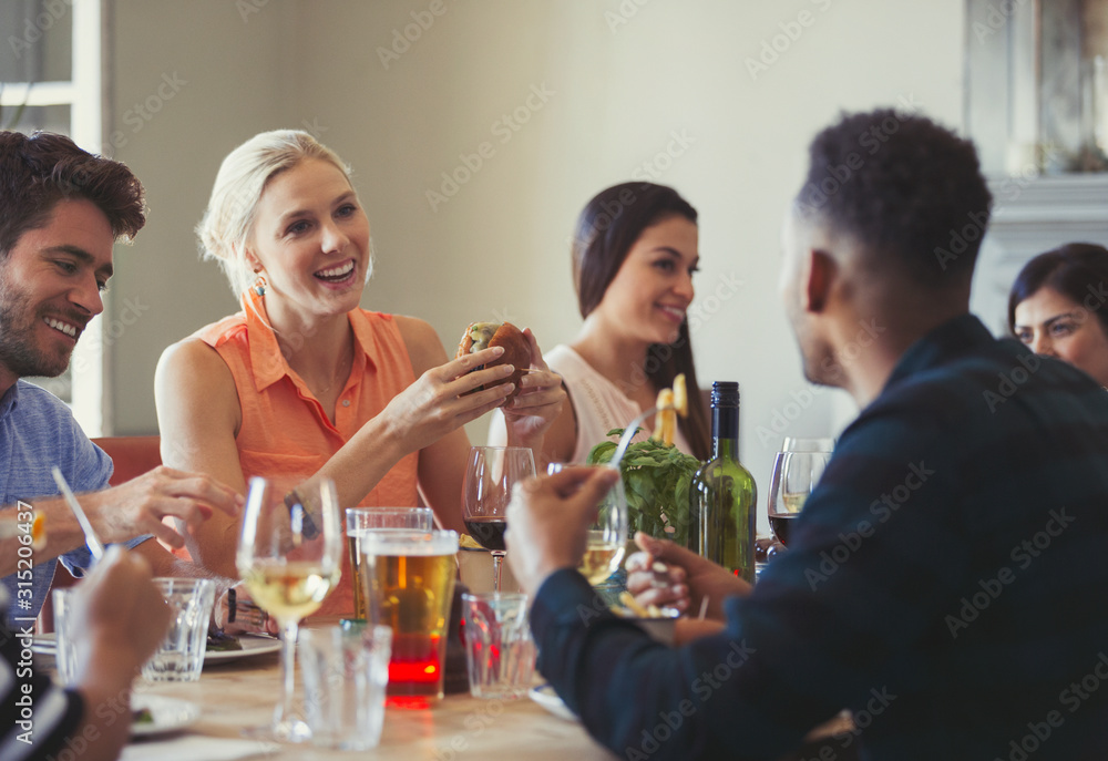 Friends talking and dining at restaurant table Friends talking and dining at restaurant table
