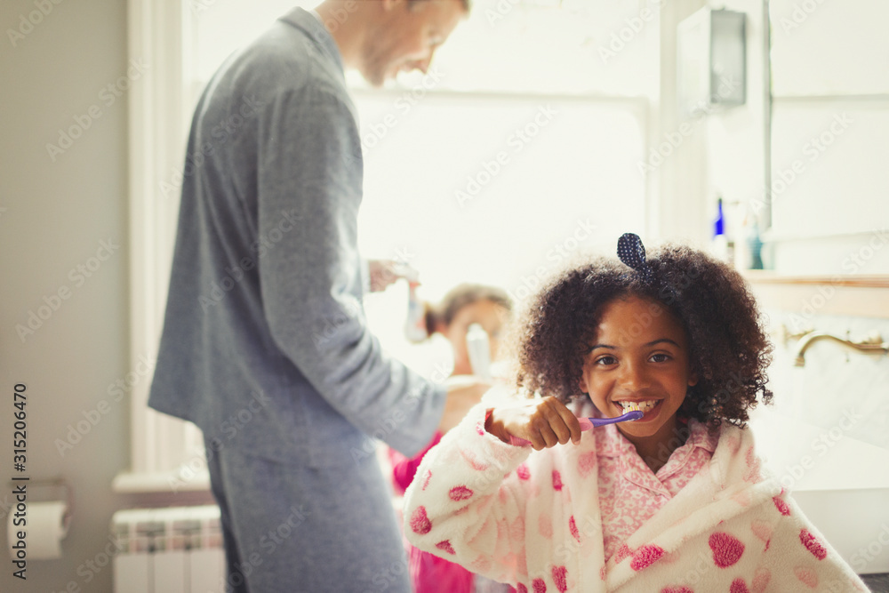 Girl in bathrobe brushing teeth in bathroom Girl in bathrobe brushing teeth in bathroom