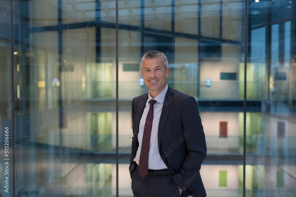 Portrait smiling, confident businessman in modern office atrium Portrait smiling, confident businessman in modern office atrium
