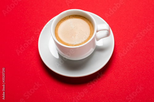 Black coffee in a cup on a red background